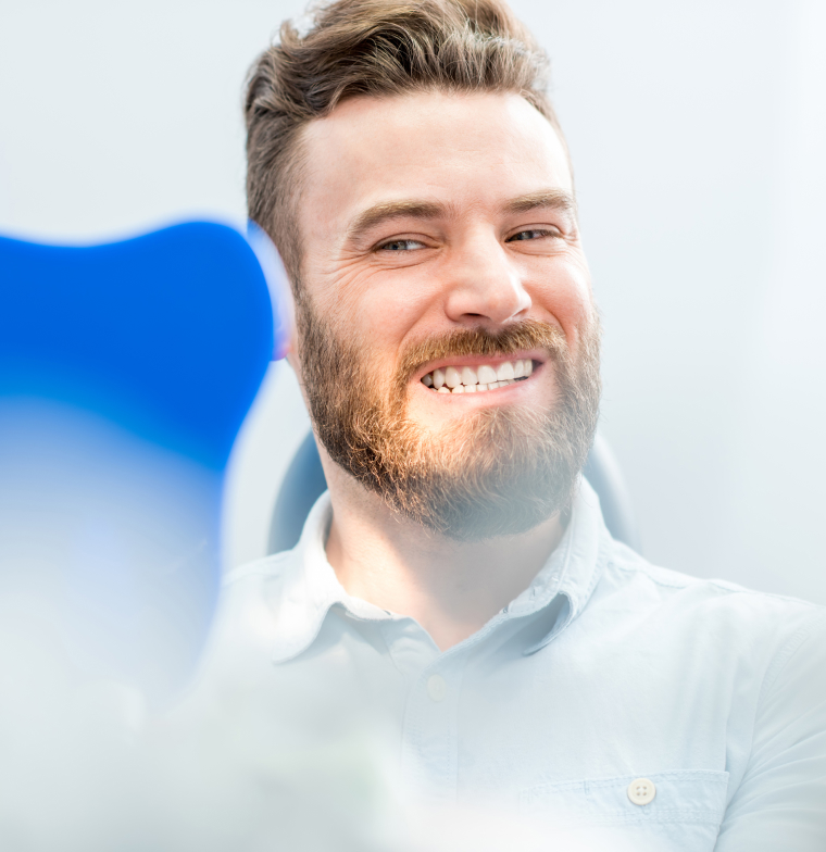 man smiling looking at hand mirror